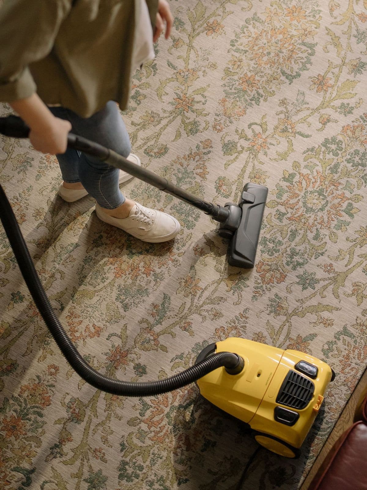 Floral rug being vacuumed during carpet cleaning