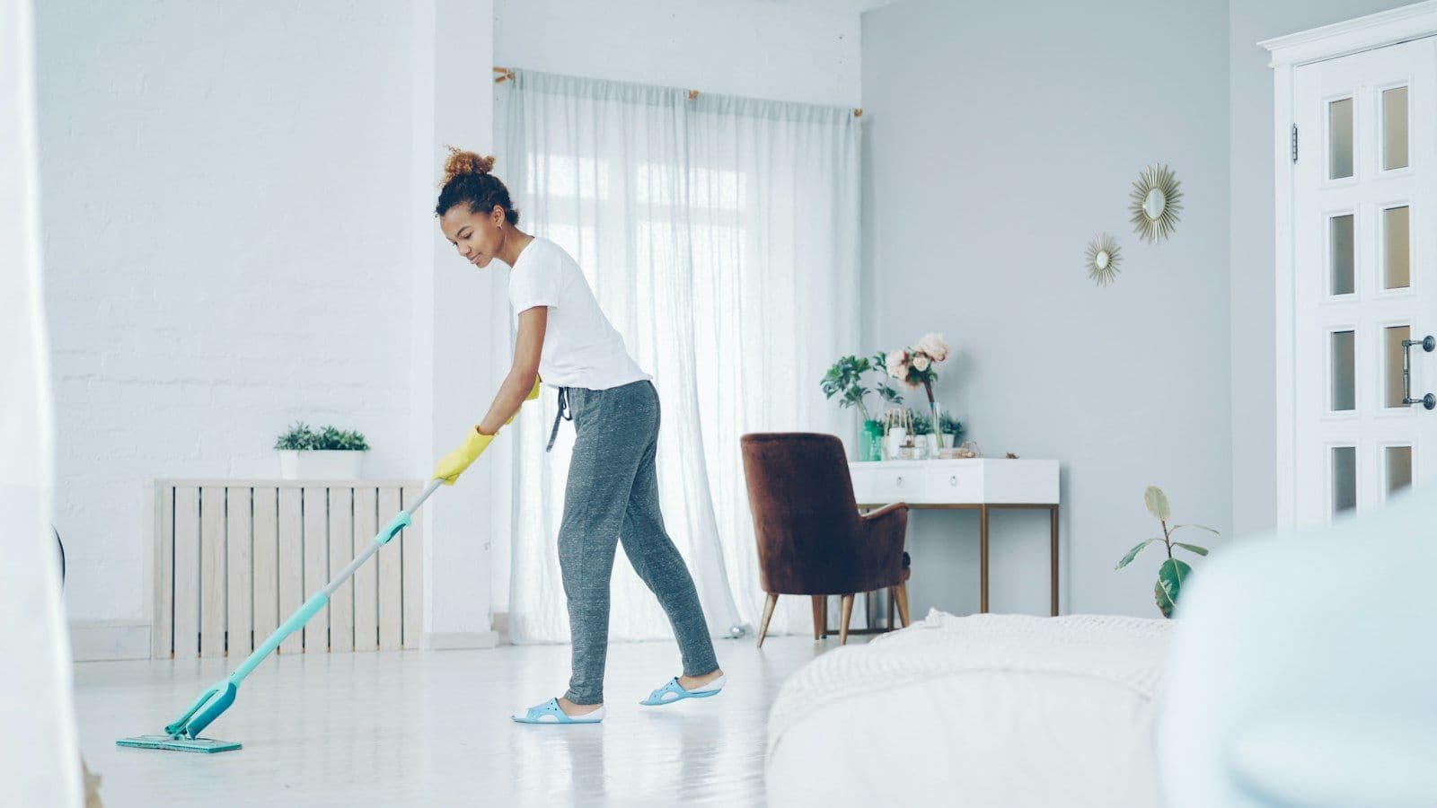 Cleaner mopping a bright living room floor